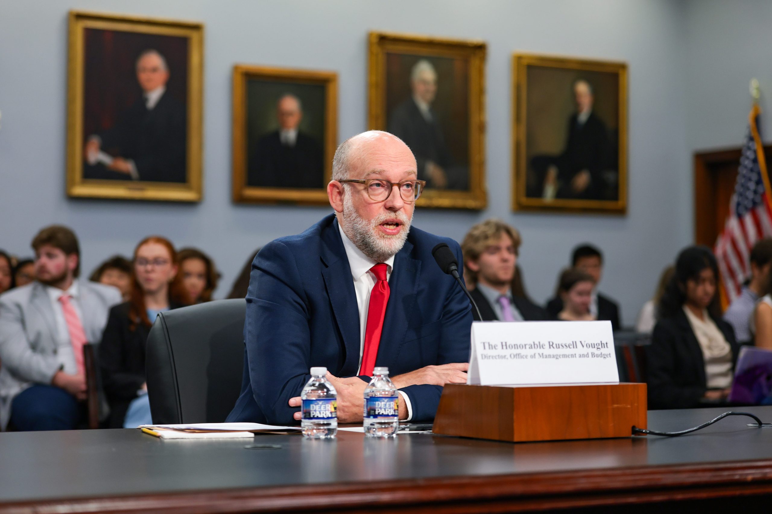 Man speaking to audience at a desk