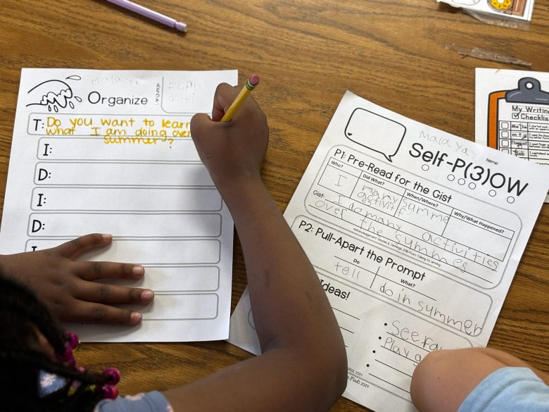 A first grader at Sand Creek Elementary fills out a worksheet to help organize thoughts before writing a paragraph about her summer plans. The Douglas County School District adopted a method of teaching writing that emphasizes structure and planning.